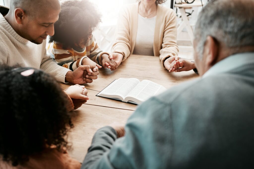 holding-hands-family-group-praying-bible-support-with-quality-time-connect-gratitude-people-believers-community-with-solidarity-religion-holy-book-with-hope-faith-god-min