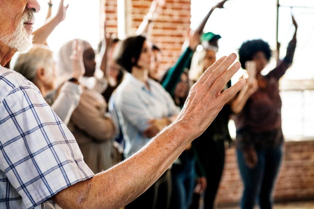 people-raising-their-hands-seminar-min